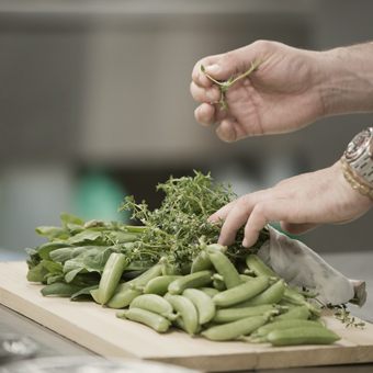 Hand preparing vegetables on a kitchen countertop