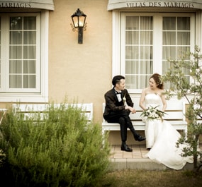 Newly weds talking to each other on a bench in front of the wedding venue